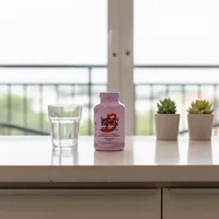Cápsulas para el metabolismo en la cocina de una casa, junto a un vaso de agua