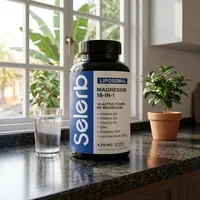 Magnesio liposomal en cápsulas en la cocina de una casa, junto a un vaso de agua