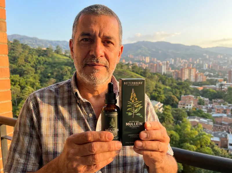 Hombre colombiano de unos 58 años en un balcón de Medellín con el frasco de gotas